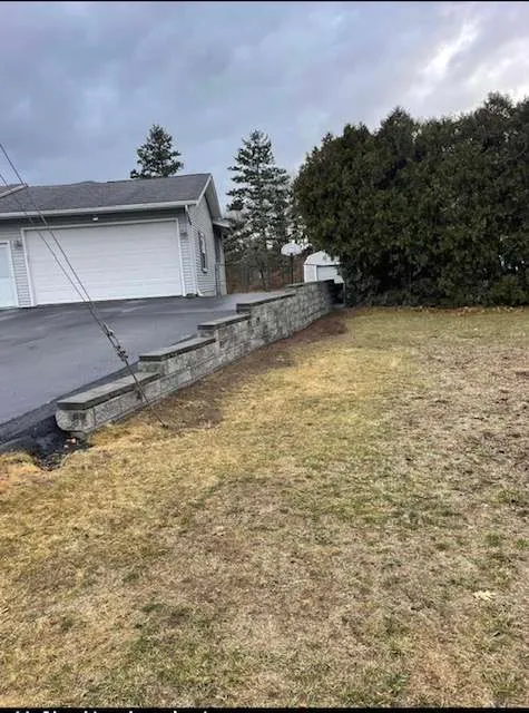 Rebuilt stone retaining wall beside the driveway