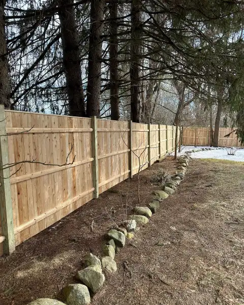 New wood fence with a fieldstone border