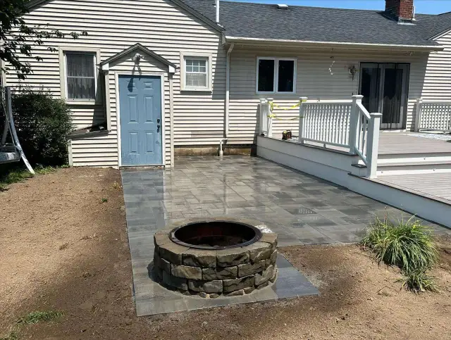 Stone fire pit set into a new paver patio